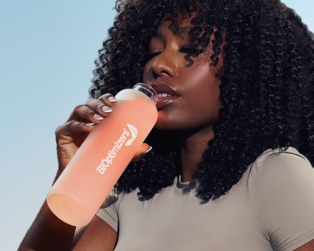 Woman drinking from a BIOptimizers bottle